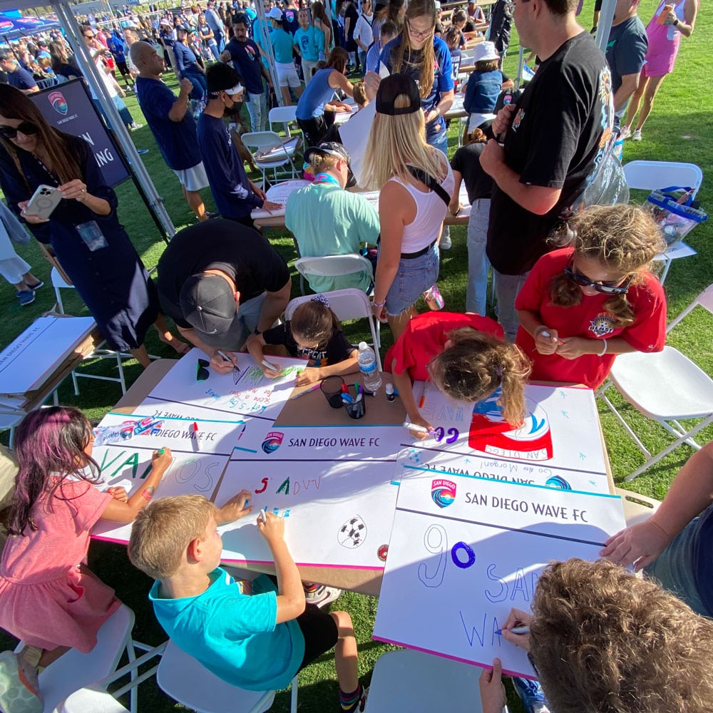 Kids drawing signs before soccer game at San Diego Wave Football Club sports marketing event