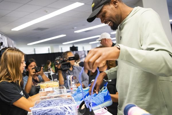 Kevin Durant helps fans lace exclusive flight 35 nike shoes at brand activation in Los Angeles, CA