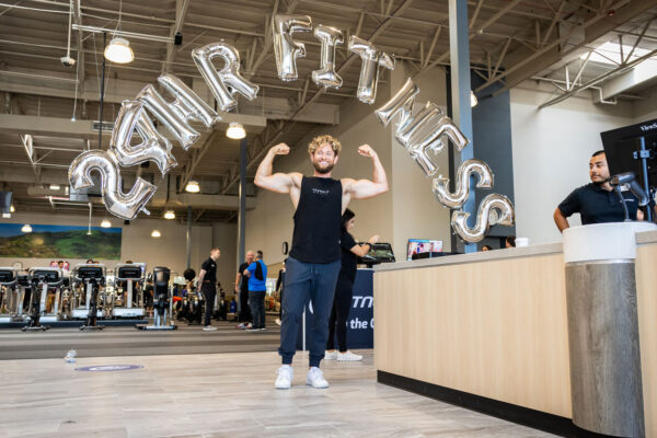 Man flexing at grand opening of experience
