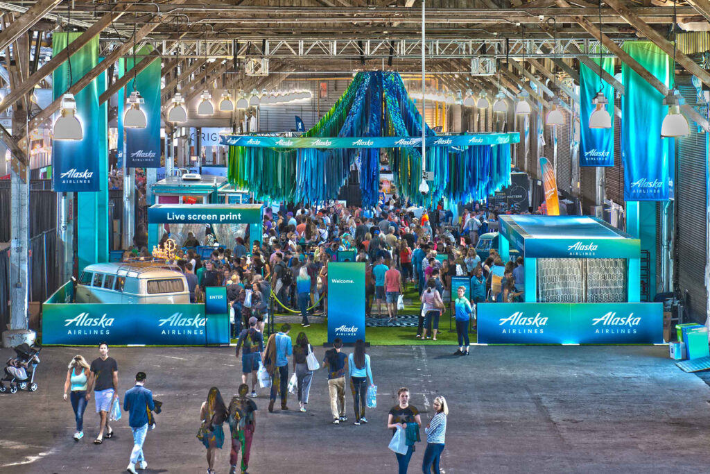 Large-scale Alaska Airlines brand activation produced by Southport Marketing, featuring custom builds, live screen printing, immersive decor, and a packed event crowd.