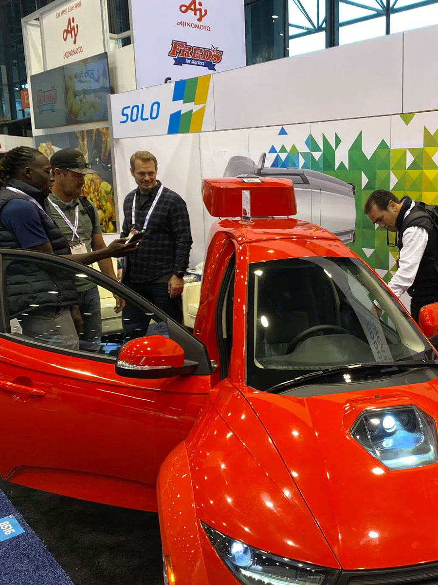 Attendees engage with a red EV at an automotive event marketing activation, showcasing experiential marketing for automotive brands and hands-on automotive marketing strategies.