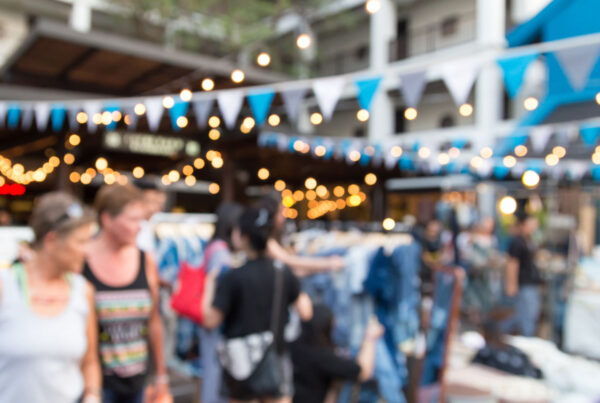 Outdoor experiential retail event with shoppers browsing pop-up displays, illustrating immersive retail experiences that drive engagement and brand interaction.