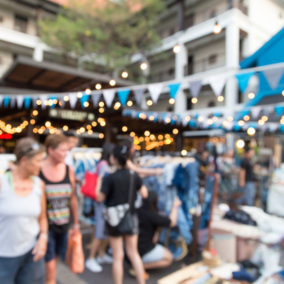 Outdoor experiential retail event with shoppers browsing pop-up displays, illustrating immersive retail experiences that drive engagement and brand interaction.