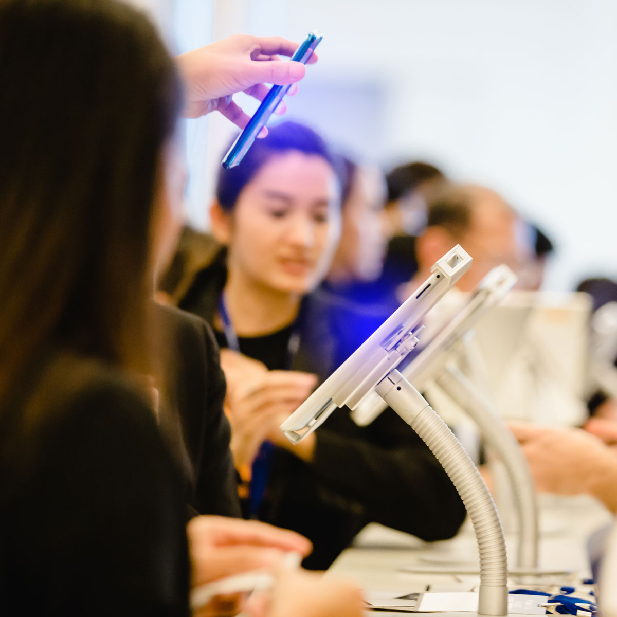 Attendees interacting with tablets at a retail product launch event, highlighting experiential marketing strategies that drive engagement and elevate brand visibility.