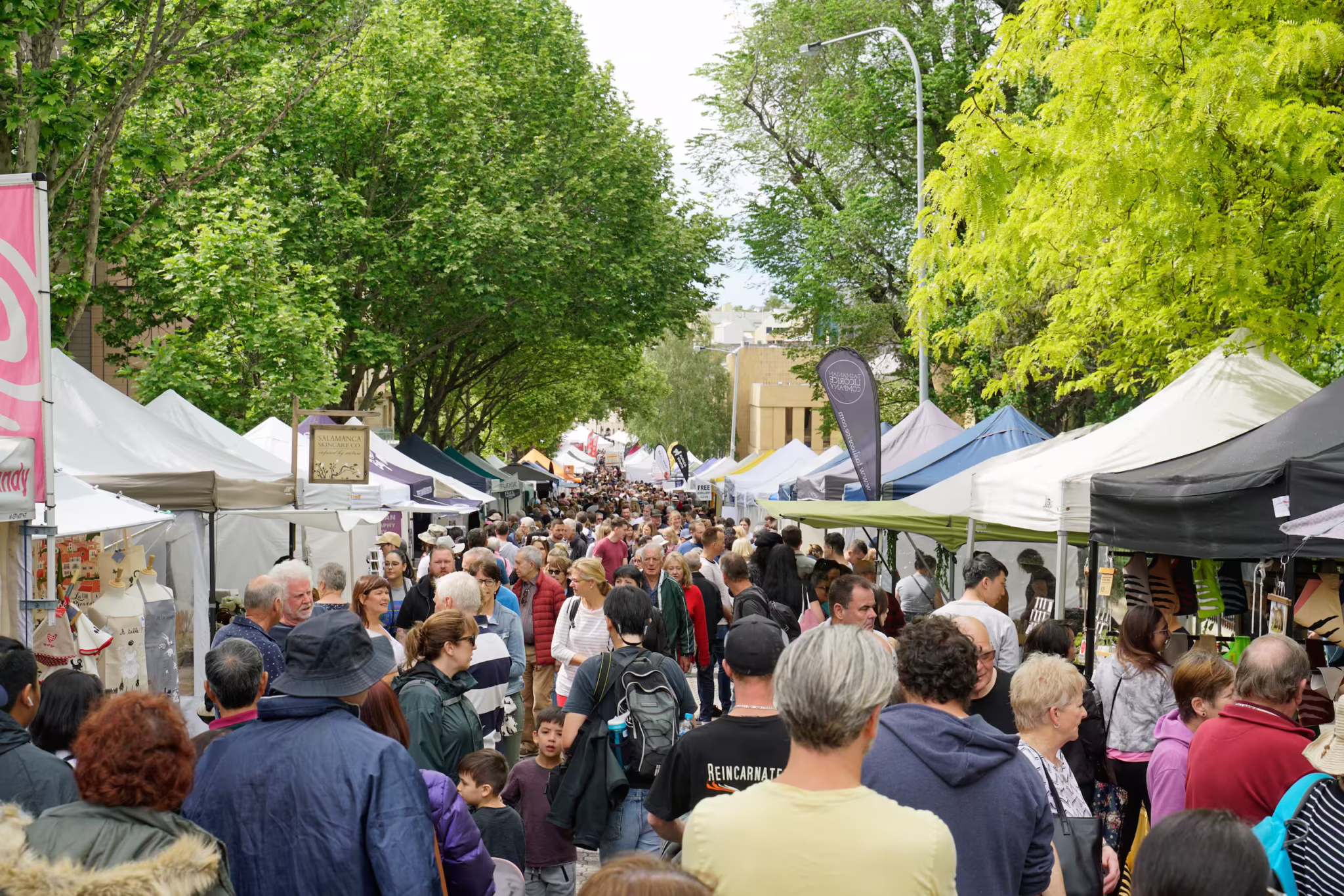 Crowded street market with vendor tents, a typical setting for CPG pop-ups and product sampling.